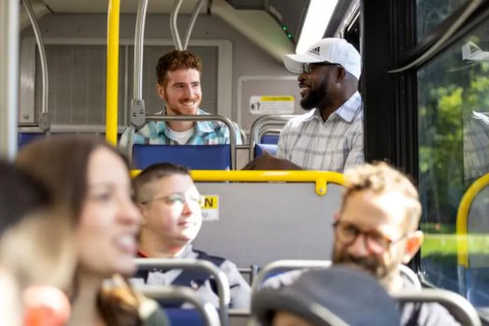 Group of cheery riders inside a CDTA public transit bus.